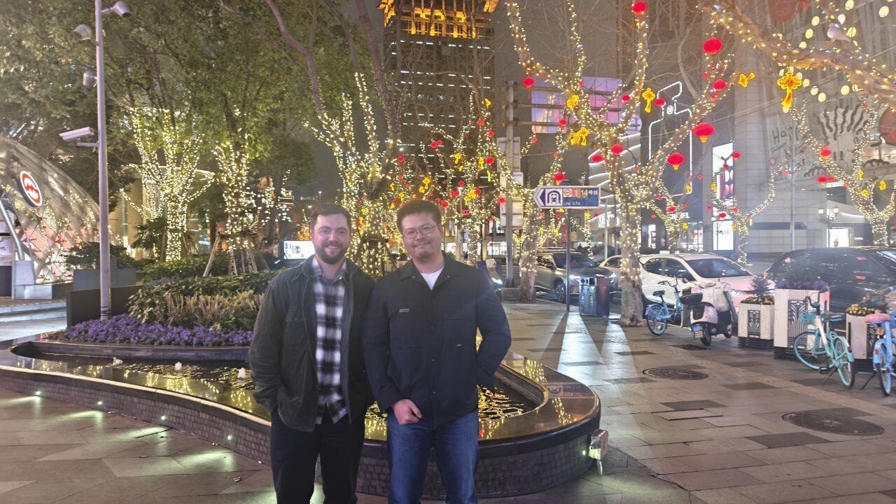 Two Avalonia team members on a city street in China lit by festival lights