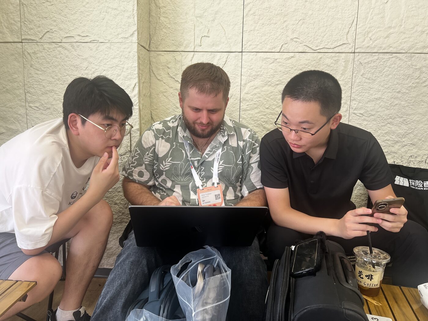 An Avalonia team member working through a problem on a laptop with two developers at a conference