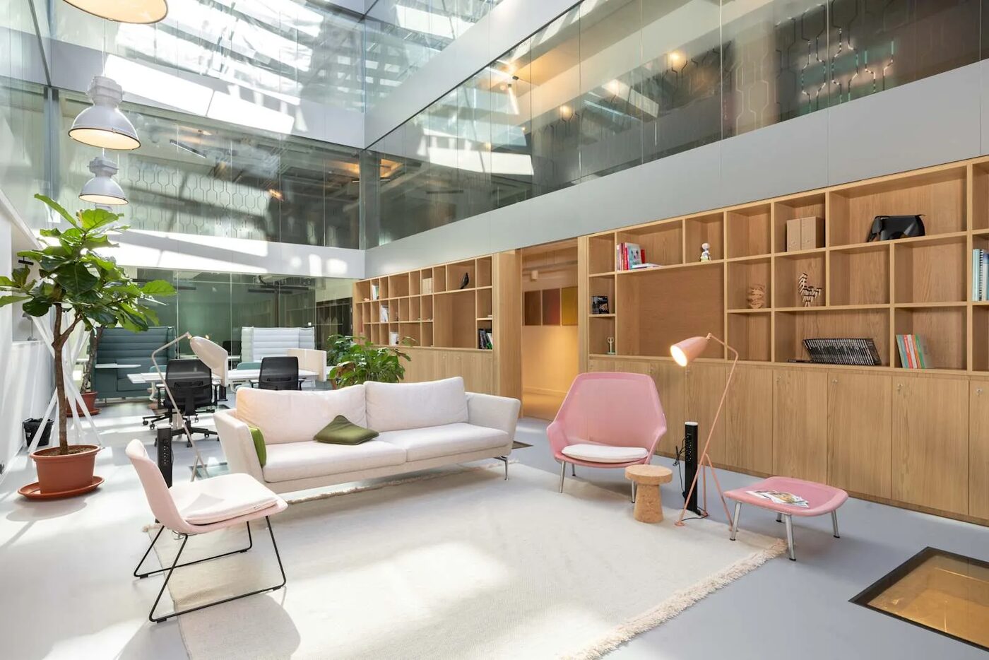 The glass-roofed atrium lounge of the Tallinn office with sofas and bookshelves