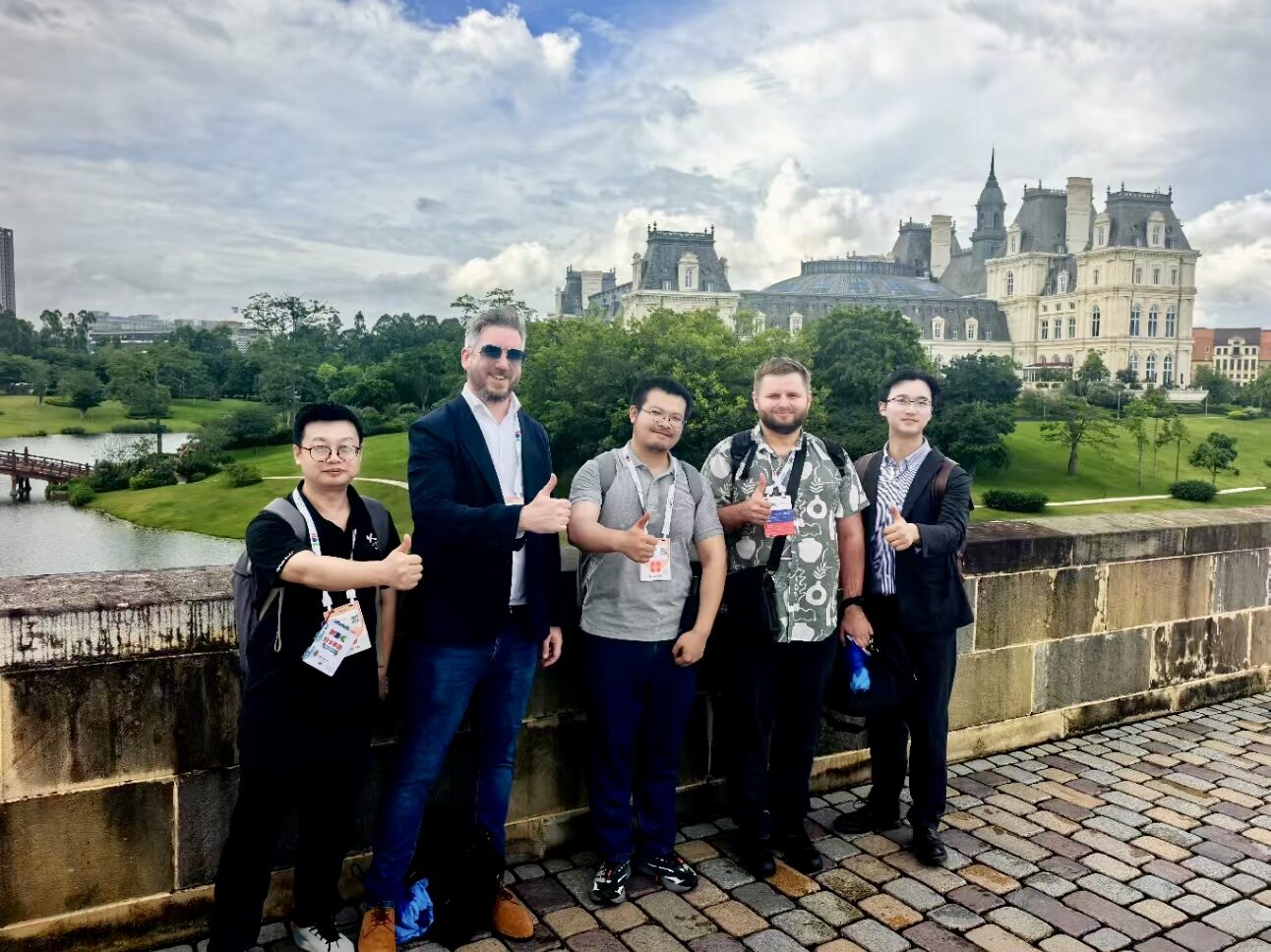 Five Avalonia team members on a bridge in front of a palace during a team meet-up